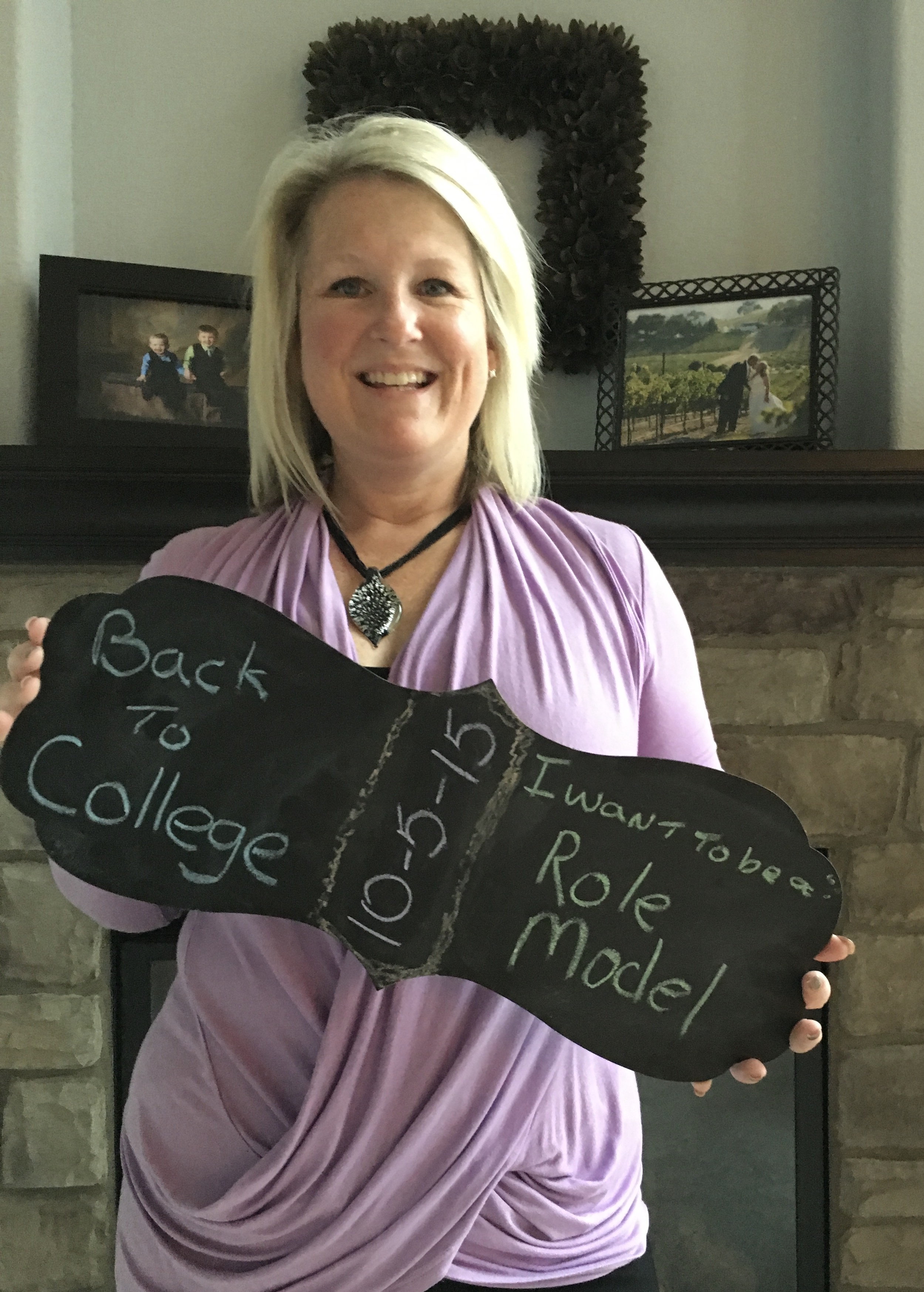 Tami Garrison First Day of School picture in her home holding a sign